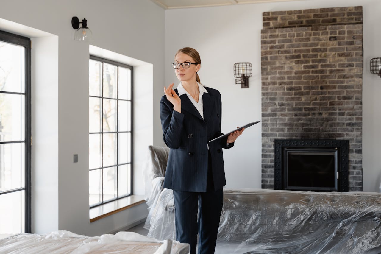 why-choose-us A confident real estate agent inspecting a modern home's interior with fireplace and large windows.